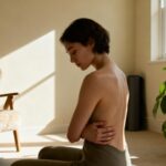 Person sitting alone in a sunlit room, reflecting quietly — symbolizing emotional self-validation and healing.
